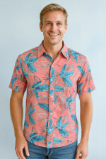 A pink tropical print shirt with blue leaves, paired with blue jeans, standing against a light blue background.